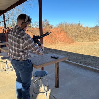 Student shooting rifle at outdoor range during training